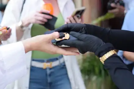An attendant passing a caviar blini to a guest